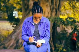 Image of a student reading outdoors