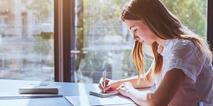 Image of woman making notes on a table