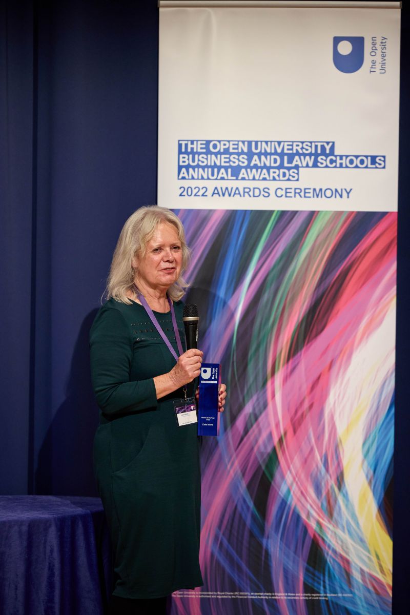 Celia Morris on the stage holding her award