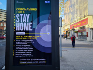 Stay at home poster displayed at a bus stop