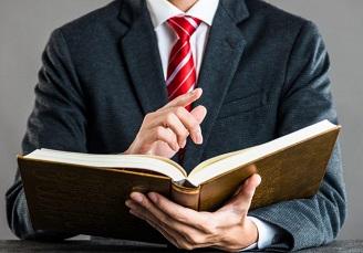 Man in suit looking through book