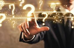 Image of a businessman with his finger to a question mark