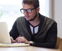 Image of man at desk with laptop