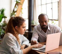 two people looking at a laptop